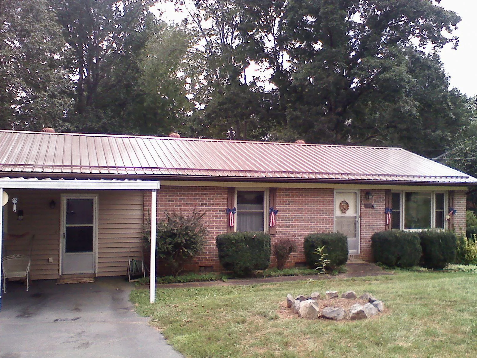 Bronze metal roof and carport on a brick ranch home — Roof Repair work by our crew in Calera