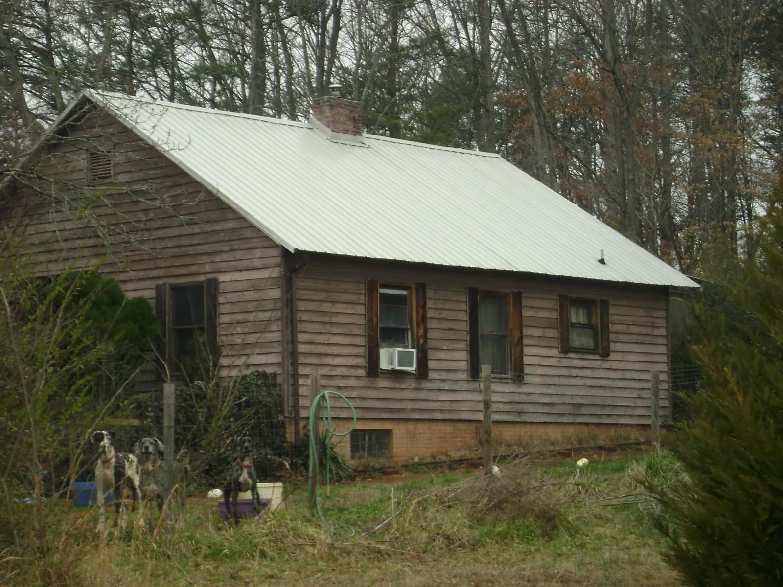 White metal roof on an old wood sided farmhouse, from a Metal Roof Installation job in Calera